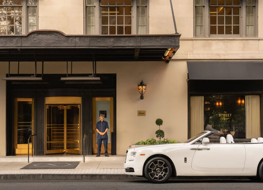 a white car parked in front of a hotel